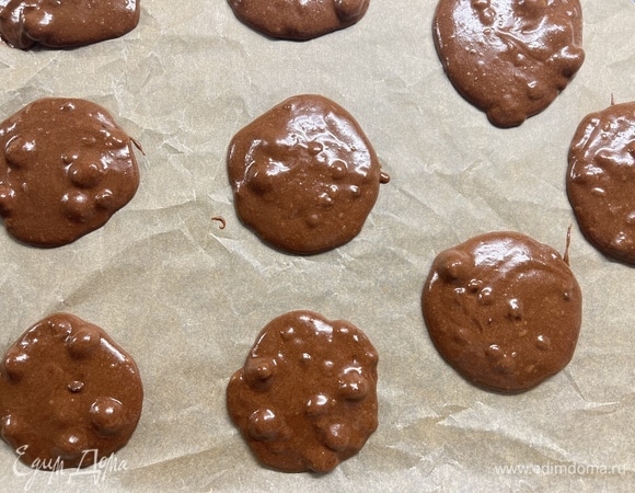 На противень, застеленный пергаментом, выложить по 1 ст. л. теста на расстоянии примерно 3 см друг от друга (если тесто кажется слишком жидким, дайте ему постоять минут 5, оно станет гуще). В духовке печенье увеличится. Выпекать при 180°C 12–15 минут.