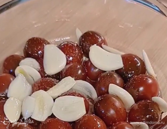 Выкладываем в форму помидоры, нарезанный чеснок, далее заправляем оливковым маслом и специями. После чего ставим в разогретую до 180°С духовку на 20 минут.