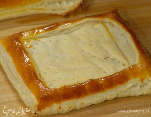 Выложить тесто на выстеленный бумагой для выпечки противень, смазать бортики яйцом и выпекать тарталетки в разогретой духовке 12–15 минут.