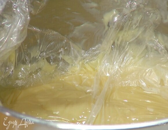 Снять крем с огня, добавить сливочное масло и перемешать, затем застелить поверхность крема пищевой пленкой и полностью остудить его.