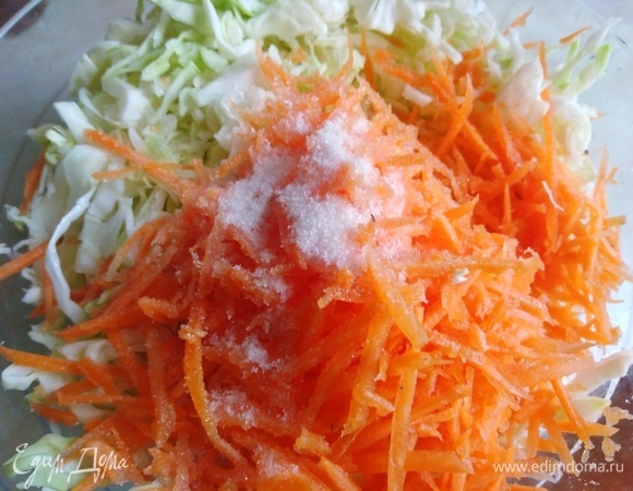 Капусту нашинковать. Морковь натереть на терке. Посолить, добавить сахар.