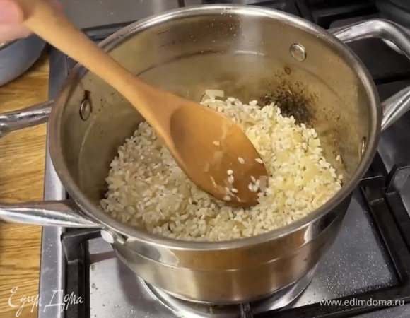 Снова добавить растительное масло в сотейник и обжарить лук до мягкости. Всыпать рис и обжарить все вместе в течение нескольких минут, постоянно помешивая.