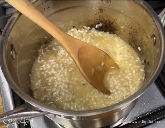 Влить горячий бульон, так чтобы он едва покрывал рис с луком. Тушить все вместе, активно помешивая. По мере выпаривания жидкости добавлять новую порцию бульона. Приправить блюдо мускатным орехом.