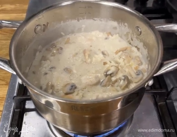 За 5 минут до готовности риса добавить в ризотто курицу и грибы, перемешать, добавить еще бульона.