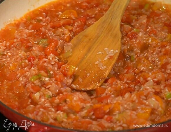 Консервированные помидоры добавить в сотейник, посолить, всыпать рис и перемешать.