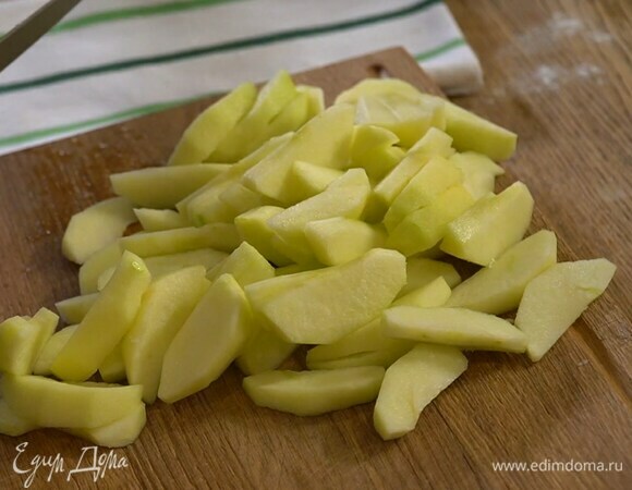 Яблоки почистить и, удалив сердцевину, нарезать дольками, затем сбрызнуть лимонным соком и выложить большую часть в тесто. Все перемешать.