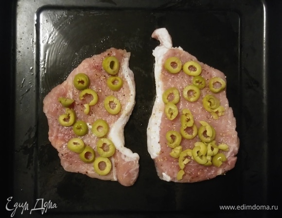 Смазать противень растительным маслом. Положить на противень мясо, а затем на мясо выложить слой нарезанных оливок.