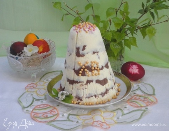 Подготовьте форму для пасхи. Застелите ее двойным слоем влажной марли, оставляя длинные части марли, аккуратно ее разровняйте. Поочередно ложкой выложите светлую, затем темную творожные части. Разровняйте поверхность. Сверху закройте пасху длинными частями марли. Положите сверху плоскую подложку (не бумажную) и груз, а форму с пасхой поставьте на тарелку. Уберите на ночь в холодильник. Внизу скопится небольшое количество жидкости. Утром аккуратно достаньте пасху из формы и украсьте по своему усмотрению.