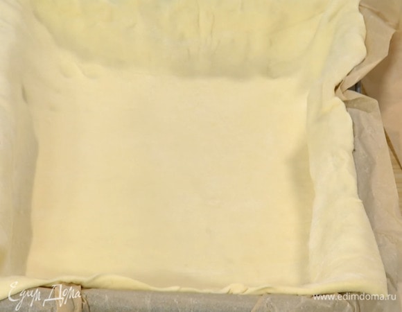 Прямоугольную форму выстелить бумагой для выпечки, выложить тесто, так чтобы получились высокие бортики, и часто наколоть его вилкой.