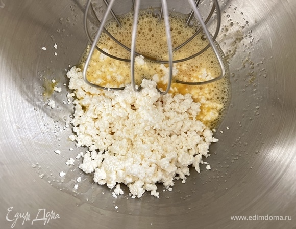 А пока яйца смешать с оставшимся сахаром и добавить творог. Перемешать.