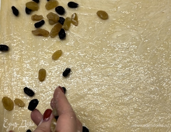 Смазать его сливочным маслом, посыпать изюмом (можно использовать цукаты, любые сухофрукты или шоколад).