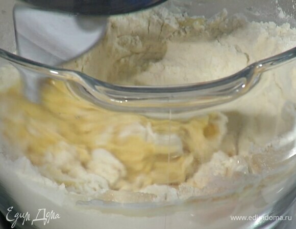 В чашу комбайна всыпать муку, дрожжи, сахар, соль и перемешать крюком для теста, затем, продолжая вымешивать, влить теплое молоко, по одному ввести яйца.