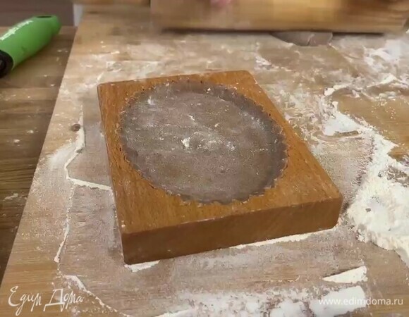 Отрежьте от общего количества теста примерно 60–70 г, разделите на 2 части, каждую раскатайте в пласт толщиной 6–8 мм и посыпьте мукой. Формочки для пряников также посыпьте мукой. Выложите тесто в форму, разровняйте, удалите лишнее тесто по краям.