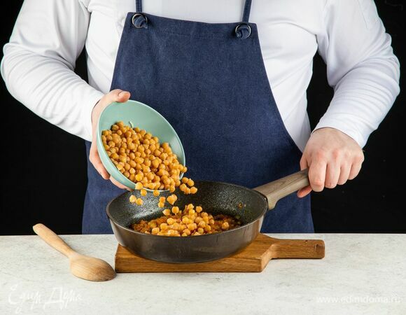 Выложите в сковороду сваренный нут.