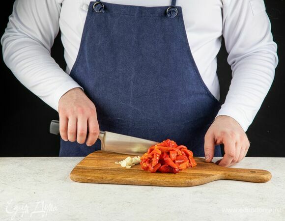 С запеченных перцев снимите кожицу, уберите семечки. Чеснок очистите. Овощи нарежьте.