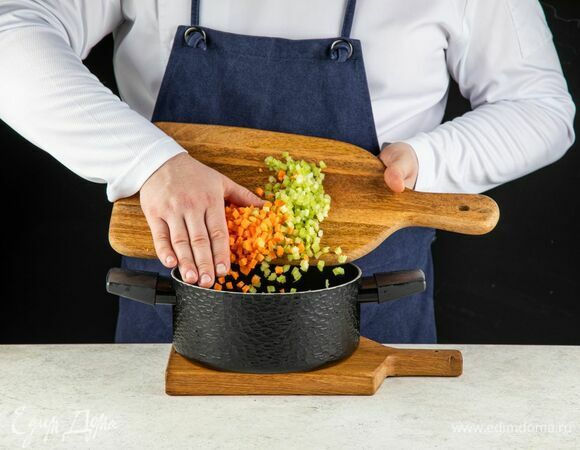 В кастрюле разогрейте сливочное масло и обжарьте лук с чесноком. Добавьте морковь и стебли сельдерея. Тушите минут 10 до мягкости, постоянно помешивая.