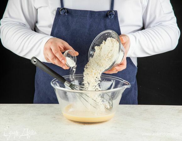 Муку просейте, соедините с разрыхлителем, всыпьте в яично-молочную смесь и замесите тесто.