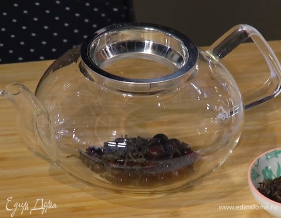 Чай и смородину поместить в заварочный чайник и залить кипятком на половину объема.