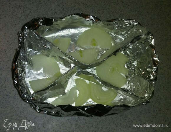 Каждую ячейку формы смазать растительным маслом и выложить в нее часть нарезанного репчатого лука.