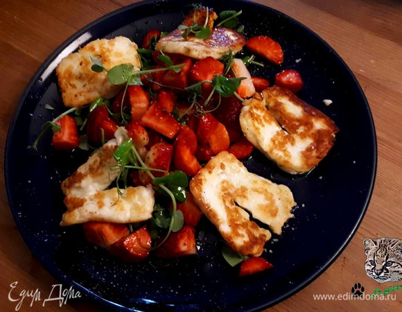 Обжарьте халуми с двух сторон. Нарежьте клубнику. 