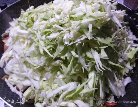 Выкладываем нашинкованную капусту, хорошо солим, накрываем крышкой и на умеренном огне тушим до полуготовности капусты.