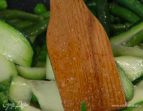 Цукини с помощью овощечистки нарезать тонкими полосками и отправить к овощам, все посолить и перемешать.