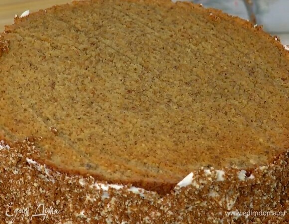 Один корж смазать кремом и накрыть вторым коржом, бока пирога смазать оставшимся кремом, посыпать бисквитной крошкой и прижать ее руками.