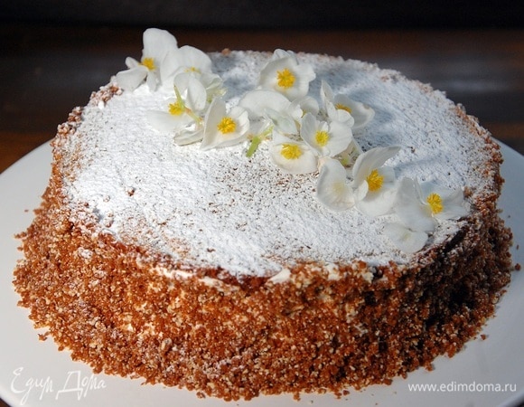 Присыпать пирог сахарной пудрой и украсить кондитерскими цветами.