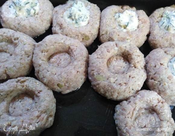 Сформировать котлеты. Выложить в смазанную форму. Сделать в фарше выемку. Выложить начинку.