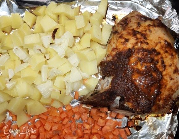 Карбонад смазываем аджикой. Выкладываем на противень карбонад, картофель, лук и морковь. Запекаем 30 минут при 180°C.