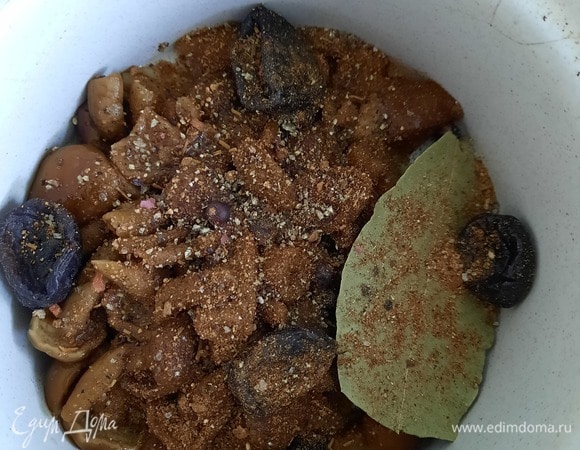 Выкладываем в горшочек грибы, чернослив, ягоды можжевельника, лавровый лист, перец черный, соль, запеченный картофель, лук, карбонад (нарезаем тоже кубиком), морковь. Заливаем 150 мл грибного бульона, закрываем крышкой. Ставим в духовку на 45 минут при 180°C.