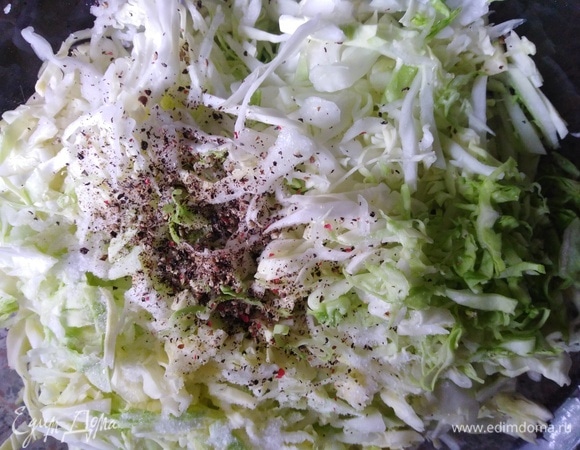 Капусту мелко нашинковать. Посолить, посыпать перцем. Помять руками.