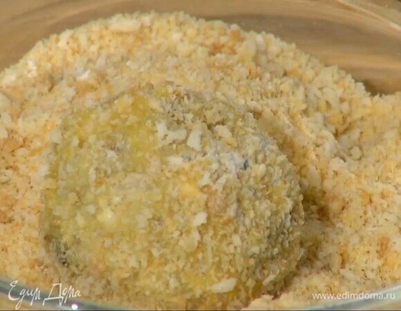 Из ризотто сделать маленькие лепешки, поместить в центр каждой кусочек сыра и сформировать шарики, обвалять их в муке, обмакнуть в яйцо, затем обвалять в панировочных сухарях.