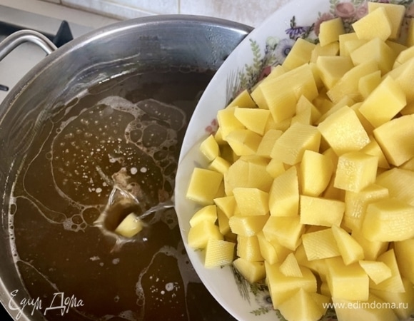 Штук пять картофелин среднего размера почистить, нарезать удобными для поедания брусочками и отправить в кастрюлю с бульоном и перловкой. Можно, конечно, и в отдельной кастрюле картошку варить, но зачем множить сущности. Уверяю вас, если картошку отправить в кастрюлю на пятнадцать минут позже перловки, то готовы они будут в одно время и друг другу не помешают.