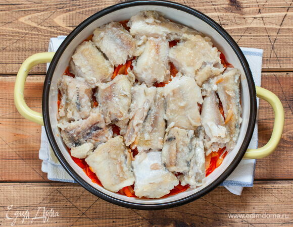 Возьмите глубокий сотейник. Выложите на дно часть маринада, на него — обжаренный минтай и еще один слой маринада. Накройте крышкой или фольгой, поставьте в духовку на 20 минут при 160–180°C. Если маринад получился слишком густым, добавьте немного воды.