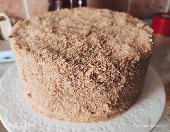 Поставить разъемную форму и положить в нее первый корж. Выложить на него 3 столовых ложки крема. Так чередовать до последнего коржа. Крем должен остаться, он понадобится, чтобы потом обмазать верх и бока торта. Поставить торт пропитаться в холодильник, лучше на ночь.