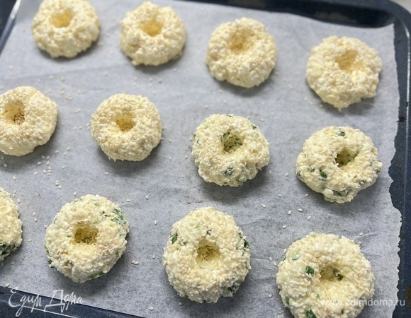 Немного прижать и сделать в центре ямочки. Посыпать тертым сыром по желанию.