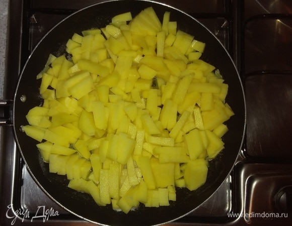 Картошку нужно почистить, помыть и нарезать брусочками. На большой конфорке плиты разогреть сковороду, смазав ее растительным маслом, затем убавить огонь до половины. Выложить в сковороду нарезанную картошку и жарить до готовности, помешивая. За 5 минут до конца приготовления посолить.