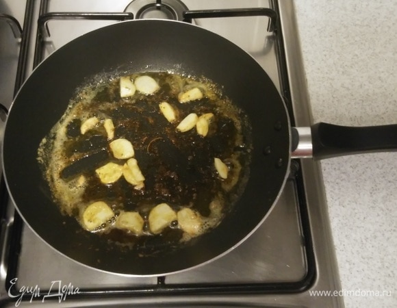 Затем выложить на сковороду нарезанные зубчики чеснока и обжарить их с двух сторон, около 2 минут.