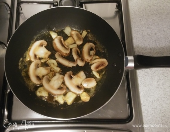 Затем добавить к чесноку шампиньоны. Обжаривать их с двух сторон до золотистого цвета.