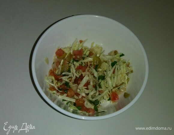 В пиалу выложите все нарезанные ингредиенты: капусту, лук, оливки, зелень петрушки, мякоть помидора. Добавьте соль, сушеный молотый чеснок, оливковое масло. Все перемешайте и начините полученной смесью помидор (так, чтобы он остался целым). Затем положите помидор на тарелку и уберите на 20 минут в холодильник. Готово, приятного аппетита!
