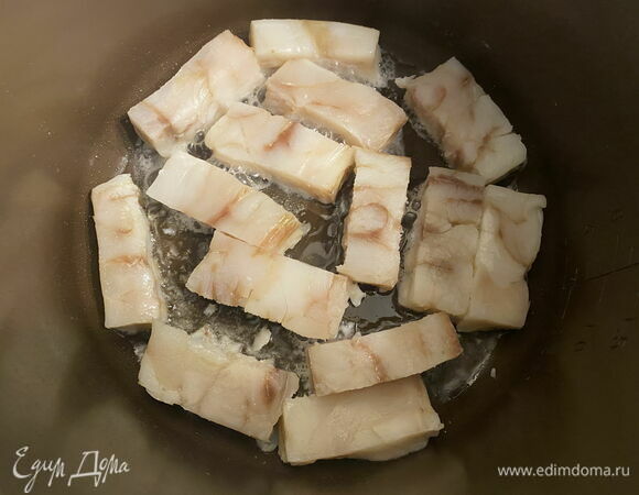 В нагретую чашу мультиварки влейте 2 ст. л. растительного масла, дайте ему нагреться. Выложите минтай и обжарьте до готовности с каждой стороны. Важно не пересушить рыбу. <br />
Если вам удобнее, обжарьте рыбу на сковороде, а мультиварку используйте для приготовления маринада. 