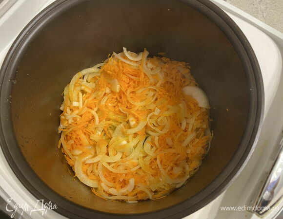 Отправьте в чашу морковь и лук, перемешайте. Переключите мультиварку на режим «Тушение». Готовьте овощи до мягкости. Они должны пассероваться (размягчаться в небольшом количестве масла на медленном огне), а не жариться. В конце добавьте чеснок, перемешайте.