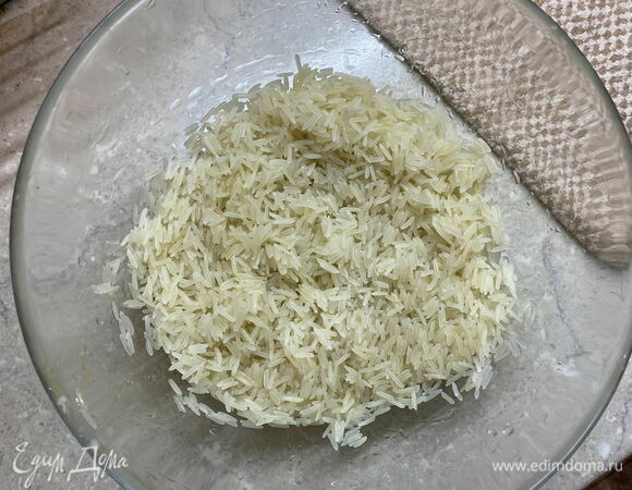 Промойте 1 стакан длиннозерного риса в воде несколько раз. Откиньте на дуршлаг и дайте жидкости стечь. 