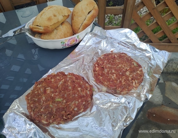 Режем 1–2 луковицы мелко, достаем фарш из холодильника, добавляем лук и хорошо перемешиваем. Берем фольгу или пергамент, смазываем его маслом и формируем котлеты диаметром примерно 15 см и толщиной около 1 см, ставим их «отдохнуть» несколько минут.