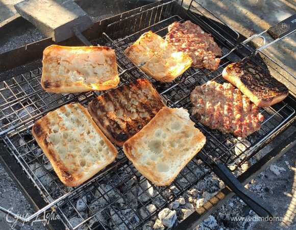 Ставим жариться наши плескавицы на гриль, предварительно смазав решетку подсолнечном маслом, чтобы котлеты не прилипли. Жарим по 3–4 минуты с каждой стороны, также добавляем к ним разрезанные пополам булочки, чтобы подрумянить.