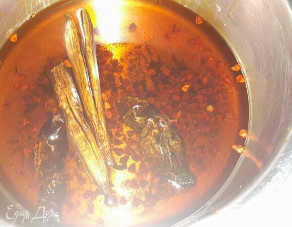 Подогрейте оливковое масло с перцем чили и ванилью. У меня на фото добавлена 1ст. л. семян ачиоте, которые и придают маслу ярко–оранжевый цвет. Когда масло прогреется до появления мелких пузырьков, убавьте огонь и оставьте на пару минут. Затем снимите с огня и дайте настояться еще 5 минут. Затем удалите специи.
