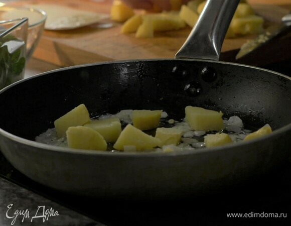 Разогрейте сковороду с растительном маслом. Мелко нарежьте лук, обжарьте до золотистого цвета. Отварной картофель нарежьте крупными кусочками, добавьте в сковороду к луку.