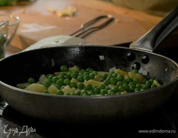 Минут через пять всыпьте в сковороду зеленый горошек, посолите.