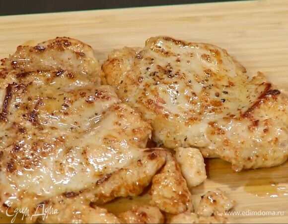 Куриное филе накрыть бумагой для выпечки и отбить скалкой, затем посолить и поперчить, разогреть в глубокой сковороде оливковое и сливочное масло, обжарить мясо до готовности и переложить на деревянную разделочную доску.